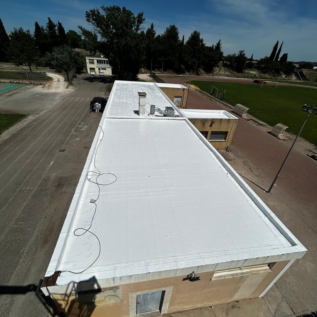 Flat roof coated with White GOAT solar-reflective waterproofing membrane to reduce heat build-up