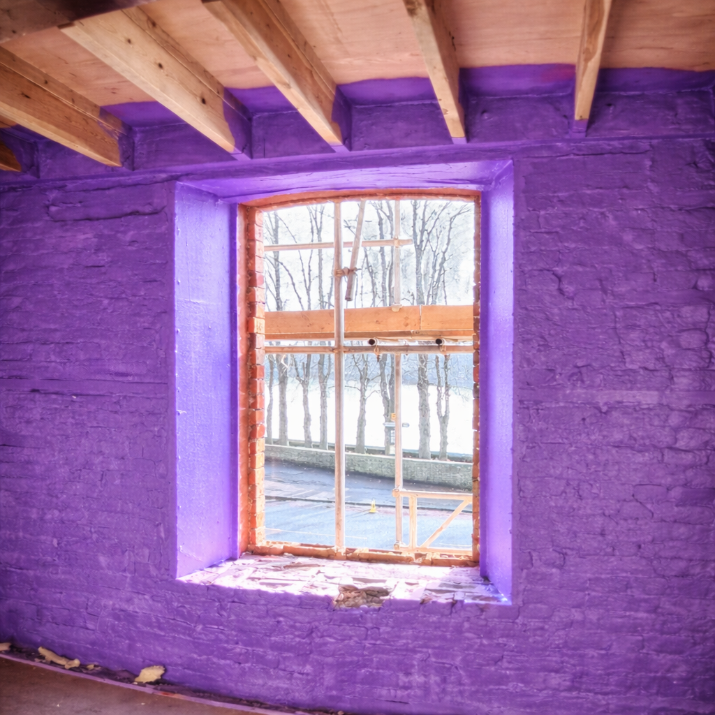 Liquid-applied airtight membrane installed around window opening in masonry retrofit.