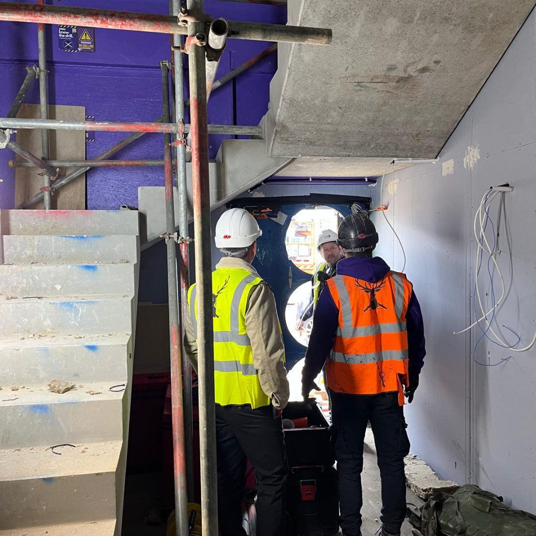 Blower door airtightness test set up on site to measure air changes per hour against the 0.6 ACH Passivhaus target