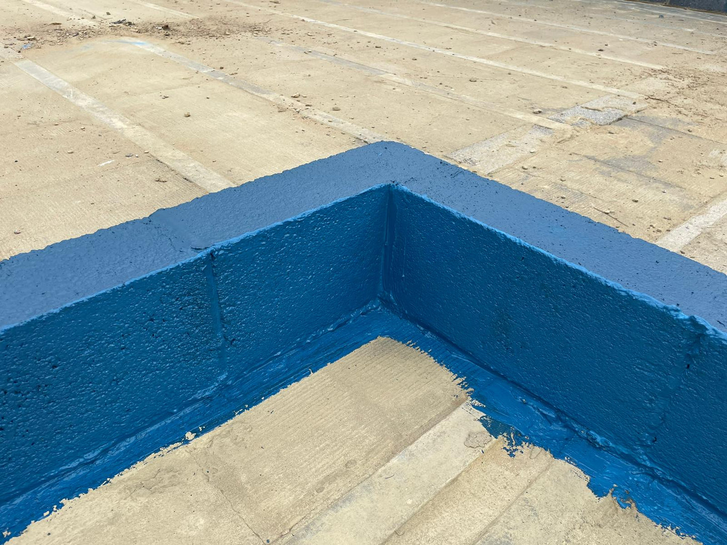 “Protective waterproof DPM liquid paint forming barrier on kicker block.”